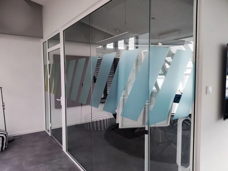 Glaswand mit farbigen Designstreifen als Glasmarkierung in zwei Höhen