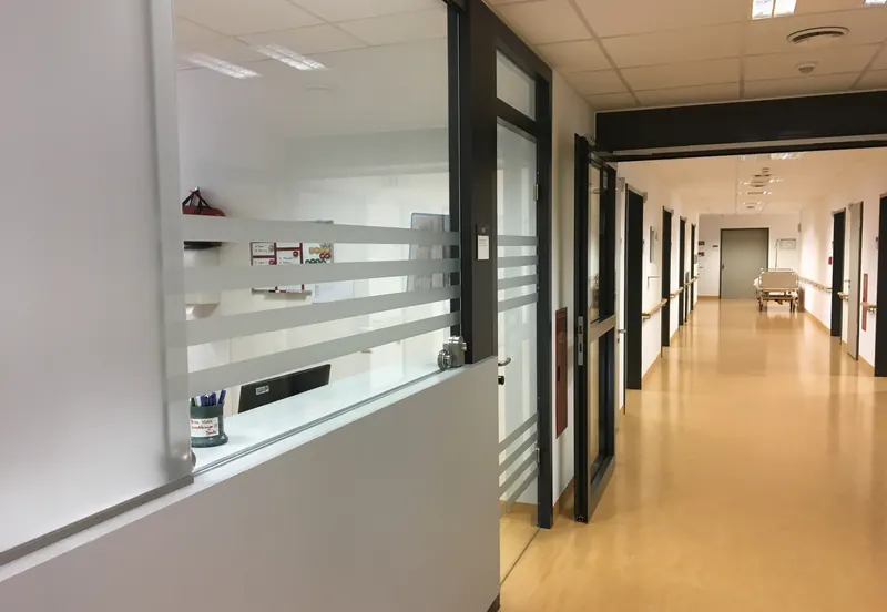 Stationszimmer in einer Klinik: Glaswand und Glastür mit Sichtschutzstreifen zum Flur