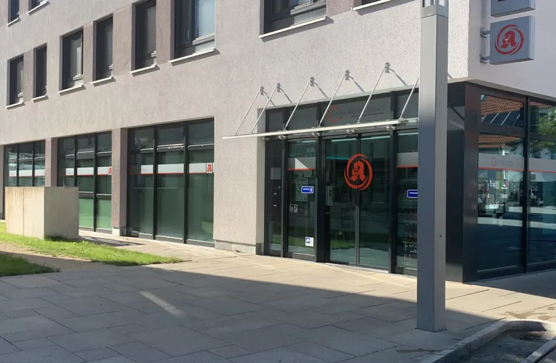 Apotheke mit umlaufendem Beschriftungsband, Logo und Schriftzug auf allen Fensterflächen