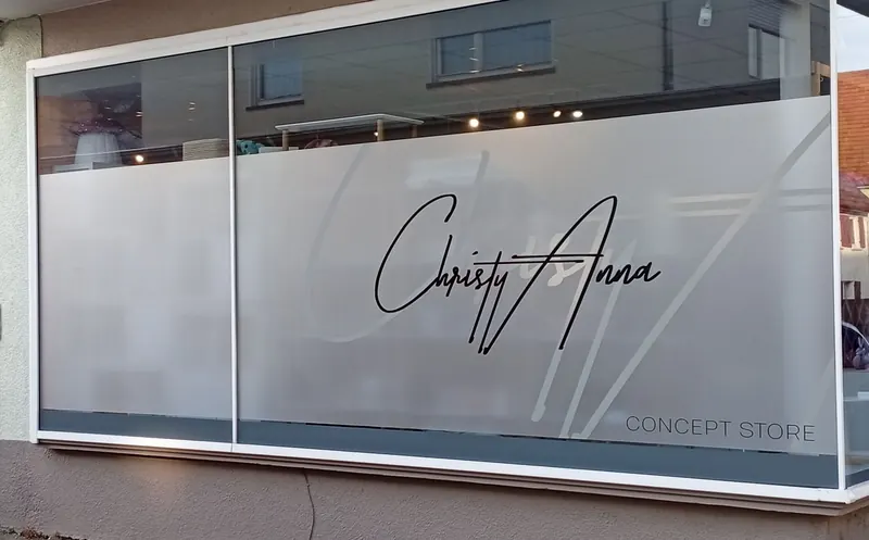 Schaufenster eines Concept Stores mit Milchglasfolie und schwarzem Logo-Schriftzug