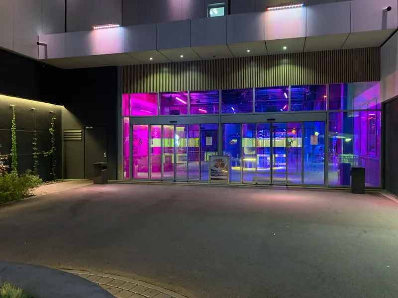 Eingangsverglasung mit farbiger Effektfolie am Abend