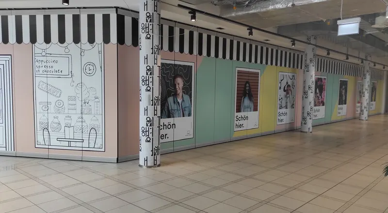 Ladenzeile in einem Einkaufszentrum, leerstehende Flächen großflächig mit Digitaldruck und Motiven gestaltet
