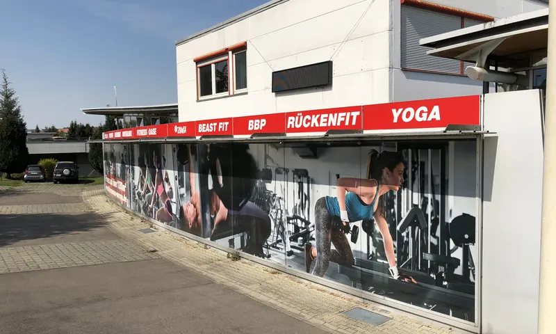 Lange Fensterfront eines Fitnessstudios, vollflächig mit Digitaldruck und Kursangeboten beklebt