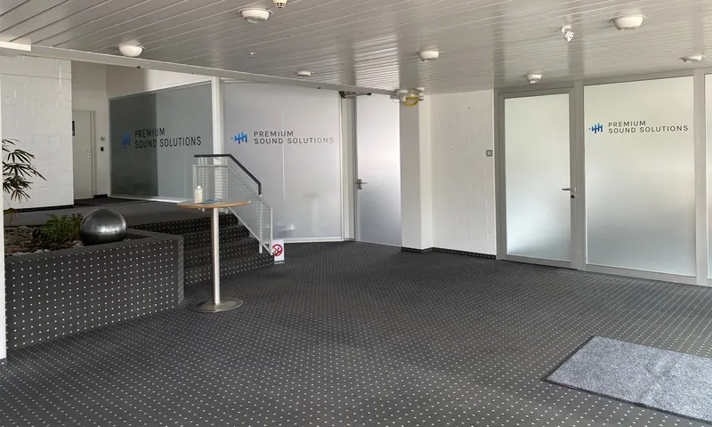 Foyer mit mattierten Glaswänden und mehrfach aufgebrachtem Firmenlogo