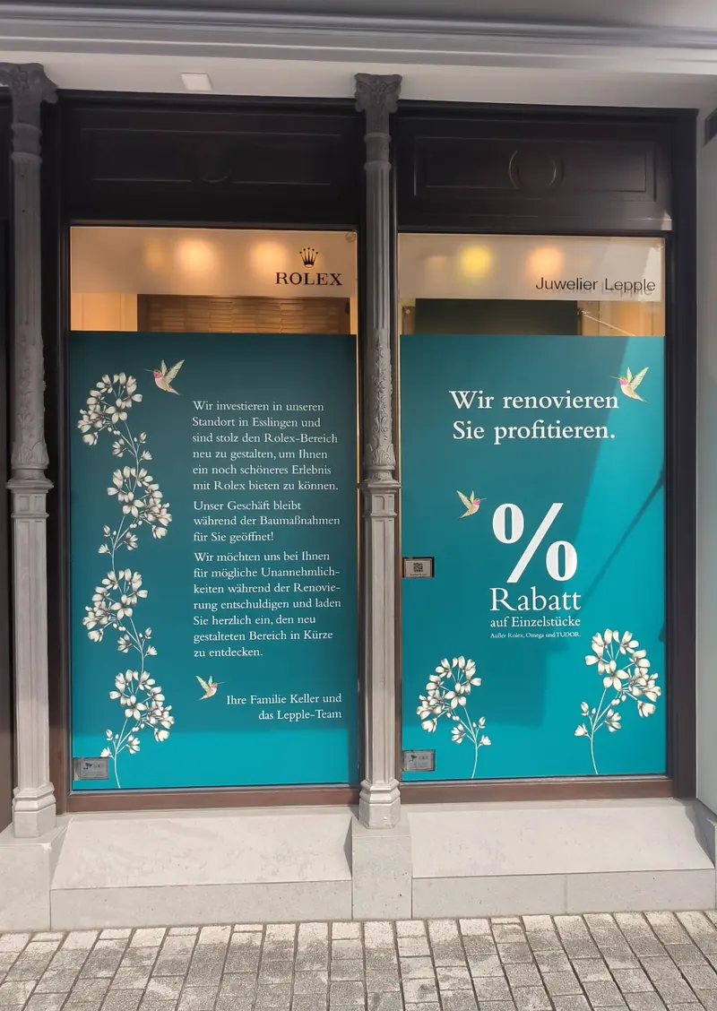 Schaufenster eines Juweliers mit großflächigem Digitaldruck in Türkis, Text und floralem Motiv