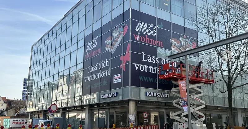 Glasfassade eines Kaufhauses über zwei Etagen mit großflächigem Digitaldruck beklebt