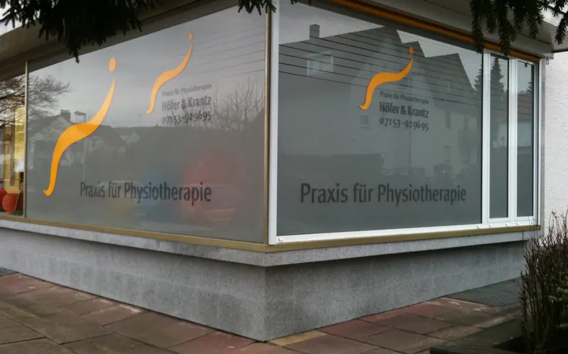 Eckfenster einer Physiotherapie-Praxis mit Milchglasfolie, Logo und Schriftzug