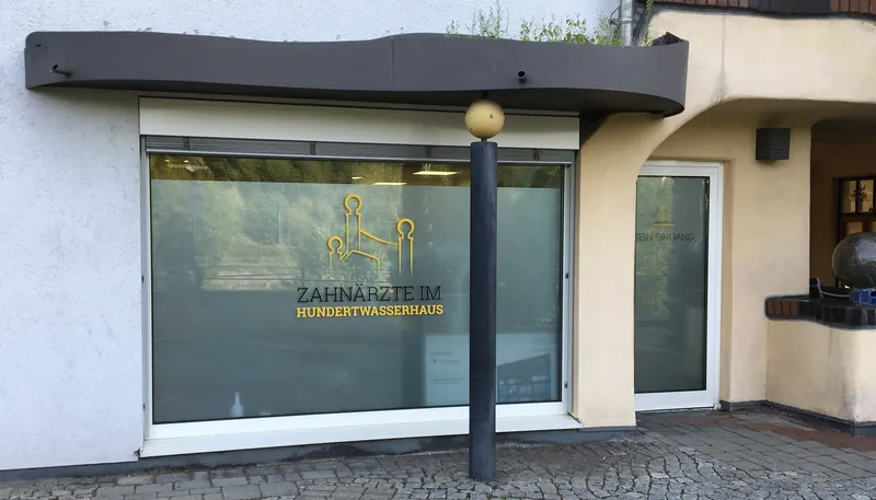 Praxisfenster mit Milchglasfolie und goldenem Logo
