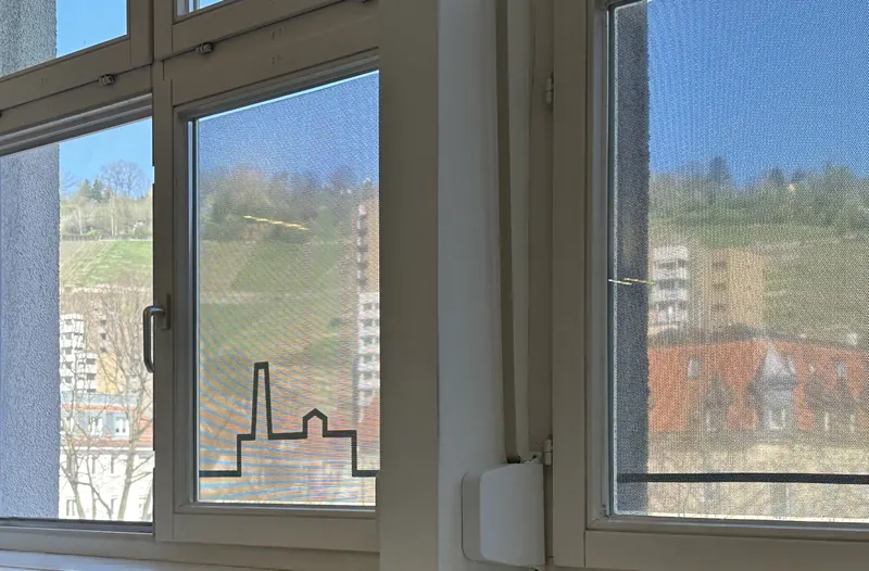 Blick von innen durch eine Lochfolie mit Skyline-Motiv: die Aussicht bleibt erhalten
