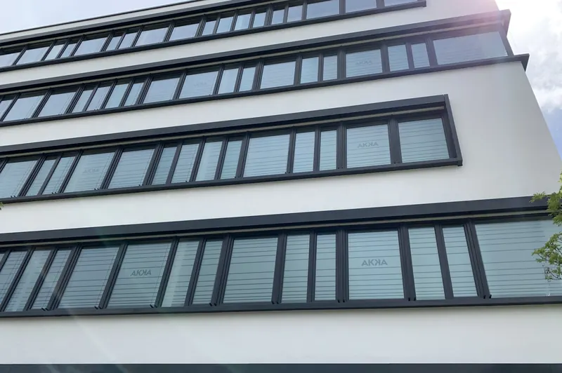 Bürogebäude, alle Fenster mit horizontaler Streifenfolie und Firmenlogo beklebt