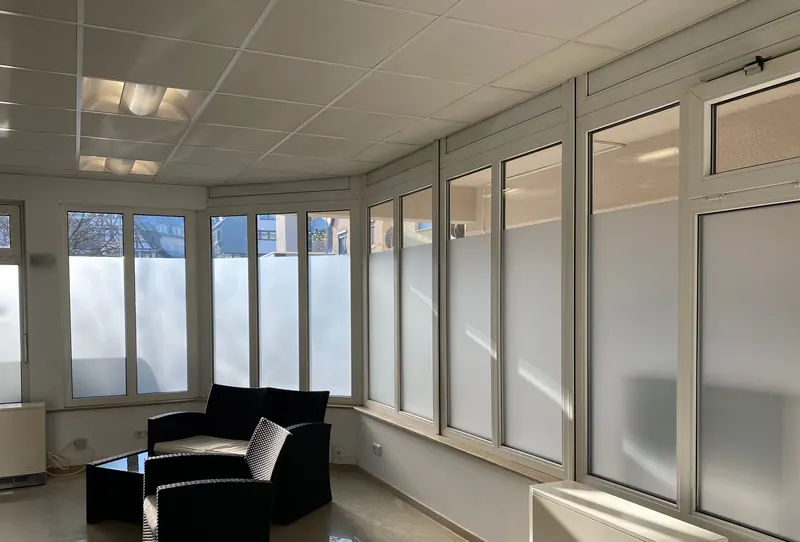 Raum mit Fensterfront, untere Fensterhälften mit Milchglasfolie, oben klar