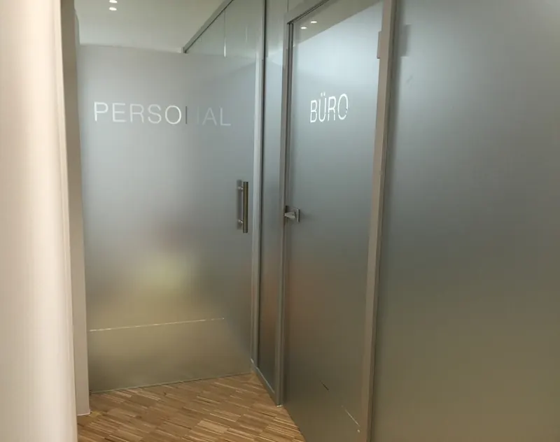 Glastüren mit Milchglasfolie und ausgesparter Beschriftung Personal und Büro
