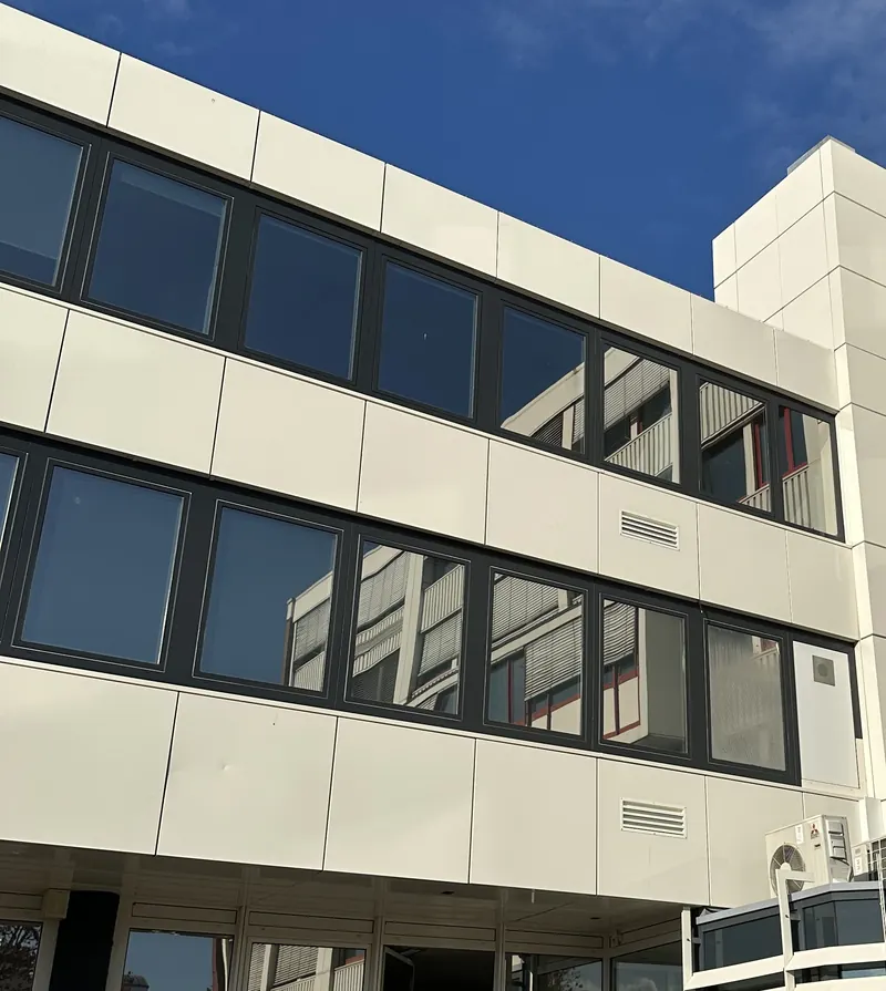 Bürogebäude mit Sonnenschutzfolie auf den Fensterbändern zweier Etagen
