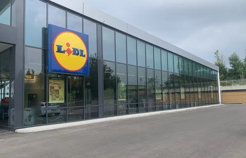 Glasfassade einer Lebensmittelfiliale mit Sonnenschutzfolie über die gesamte Fensterfront
