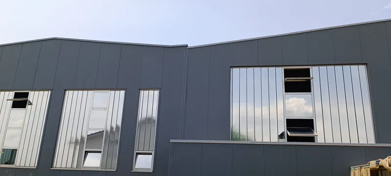 Produktionshalle mit spiegelnder Sonnenschutzfolie auf den hohen Fensterbändern