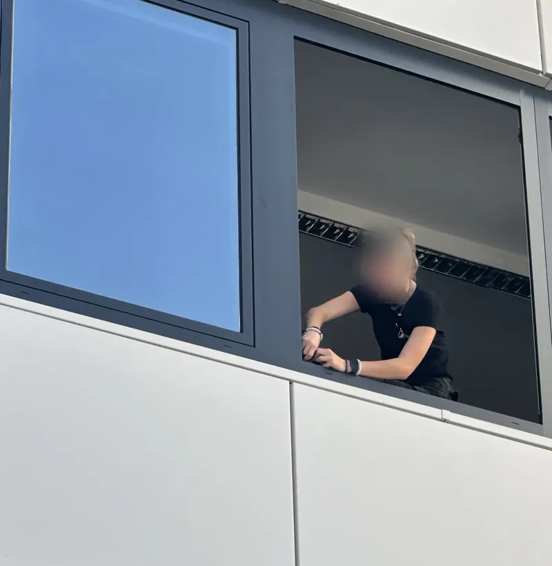 Montage einer Sonnenschutzfolie an einem Fensterband im Obergeschoss eines Bürogebäudes