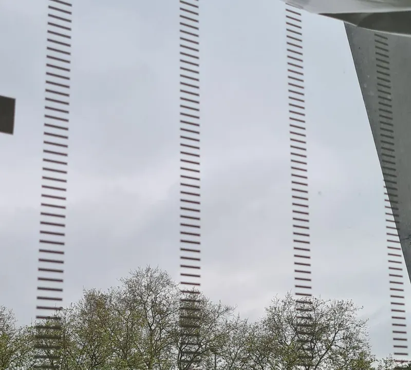 Nahaufnahme der Vogelschutzmarkierung: vertikale Linien aus kurzen Strichen auf Glas
